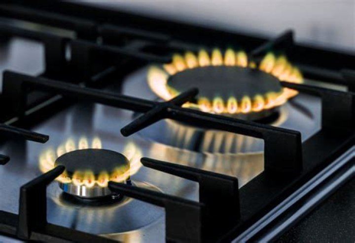What causes gas stove to have orange flame?
